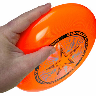 Oranje frisbee in de hand gehouden, klaar om te worden gegooid.