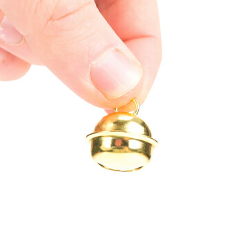 Grelot plat de 18 mm couleur or, tenu entre le pouce et l'index d'une main, avec une finition brillante et un anneau de fixation visible.