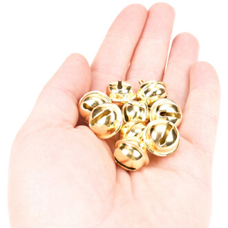 Grelots plats de 18 mm de couleur or, regroupés dans une main. Les grelots brillent à la lumière, montrant leur finition dorée.