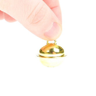 Grelot plat de 22 mm de couleur or tenu entre le pouce et l'index, avec un design sphérique brillant et une anse pour l'accrocher.
