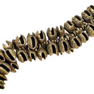 Grelots tibétains dorés de 11 mm, perles creuses gravées en rangée sur fond blanc – gros plan.