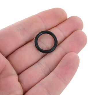 Petit joint torique noir en caoutchouc tenu entre le pouce et l’index, vue rapprochée.
