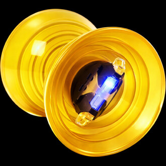 Diabolo Fluxo Beach lumineux jaune translucide avec centre noir et LED bleue, vue rapprochée sur fond noir.