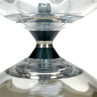 Gros plan du Kit Hyperspin Fixe Lumineux Fluxo : pièce centrale noire conique avec anneau argenté, entourée de bols transparents gravés.