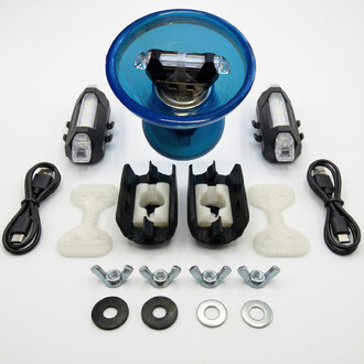 Kit lumineux Fluxo 2K pour diabolo présenté sous forme de photographie. Comprend un diabolo avec un bol en plastique bleu, deux lampes LED, des supports, un câble de chargement USB, des éléments en plastique, et divers accessoires en métal. Disposition de