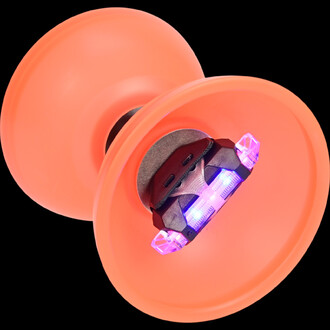 Diabolo Vision Free lumineux, de couleur orange, avec des LED intégrées visibles au centre, sur un fond noir. Les détails des baguettes aluminium anodisées sont suggérés, mettant en avant l’aspect lumineux et coloré du produit.