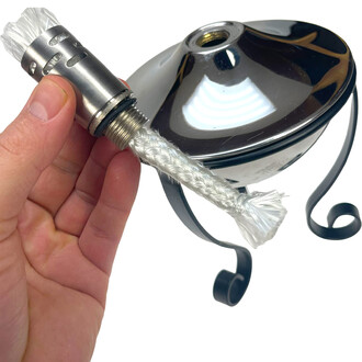 Plan rapproché montrant une mèche tressée blanche et une douille métallique filetée sur une lampe à huile torchière, avec le corps chromé en arrière-plan.