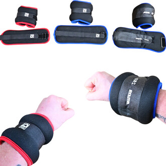 L'image montre des lestes de chevilles et de poignets. Deux poids sont visibles, l'un en rouge et l'autre en bleu, chacun portant une bande de fixation. À l'avant-plan, deux bras sont positionnés avec les lestes enroulés autour des poignets, montrant une 