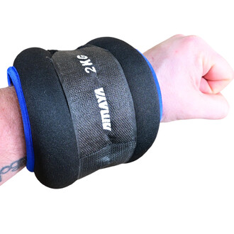 Leste chevilles et poignets de 2 kg en noir avec des accents bleus, présenté sur un poignet humain. L'image montre le produit attaché, mettant en évidence sa conception ergonomique et sa fixation.