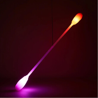 Bâton lumineux Levistick Lumi Pro LED suspendu, émettant des lumières colorées à l'extrémité, sur fond sombre.