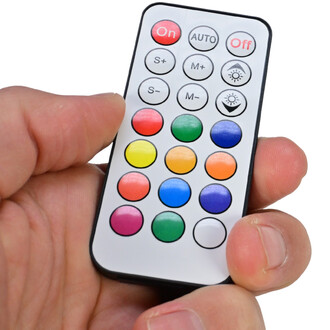 Télécommande du Levistick lumineux Juggle Dream, tenue par une main. Elle comprend des boutons de couleur pour sélectionner différents modes et effets lumineux, ainsi que des boutons On, Off et Auto.