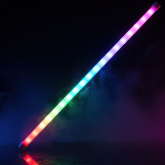 Bâton lumineux en arc-en-ciel avec des LED colorées dans un environnement sombre et brumeux, projetant des reflets sur une surface brillante.