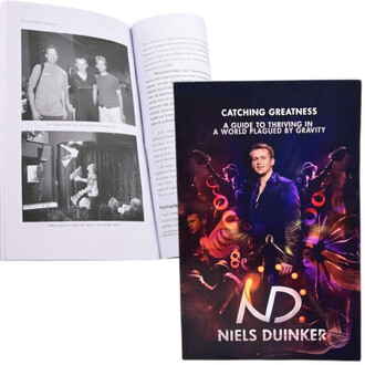 Livre Catching Greatness de Niels Duinker avec une couverture illustrée, montrant le titre, le nom de l'auteur et des éléments graphiques évoquant la jonglerie. À l'intérieur, une page ouverte avec des photos en noir et blanc de performances de jonglerie,