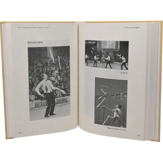 Livre Comprendium of Soviet Juggling Wisdom ouvert à deux pages, montrant trois photos noir et blanc de jongleurs en action : un homme en costume jonglant des clubs devant une foule; sur la page droite, deux clichés (un groupe de jongleurs sur scène et un