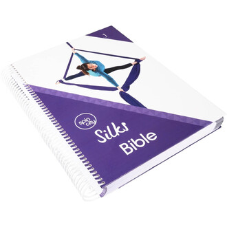 Livre spirale « Silks Bible » de Spin City, couverture violette avec une femme en tenue bleue effectuant une pose sur des tissus aériens.