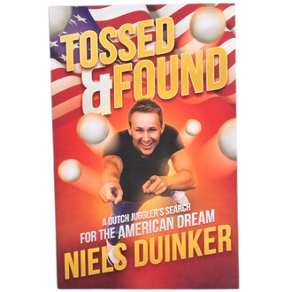 Livre Tossed & Found avec un fond coloré et des balles de jonglage. Un homme souriant, en T-shirt noir, pointe vers le spectateur, avec des drapeaux en arrière-plan. Le titre est en lettres grandes et jaunes.