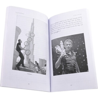 Livre ouvert Tossed & Found avec deux pages illustrées. À gauche, un jongleur en train de jongler avec des anneaux devant un bâtiment emblématique. À droite, un autre jongleur posant avec des massues sur un fond à pois.