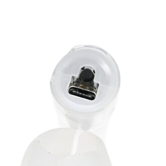 Vue plongeante sur le connecteur de chargement USB-C et le bouton de contrôle d'une tête de dragon LED lumineuse de jonglerie.