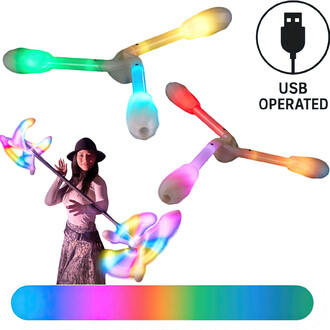 Image montrant des têtes de dragon LED de Threeworlds, avec un jongleur en tenue estivale tenant une staff lumineuse. Les têtes de dragon affichent des lumières multicolores et il y a un symbole indiquant qu'elles fonctionnent à l'USB. Un fond coloré dégr