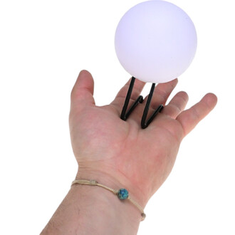Main tenant une sphère LED blanche sur un support noir. La main est légèrement ouverte, mettant en valeur la taille du produit.
