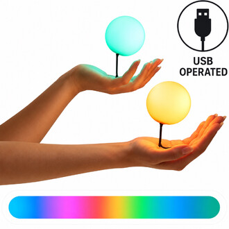 Deux mains tenant des balles lumineuses LED Lumi Pro, une bleue et une jaune, avec un pictogramme USB et un nuancier de couleurs.