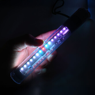 Main tenant un bâton lumineux Luminart Pixel, illuminé avec des LED multicolores visibles dans un environnement sombre.