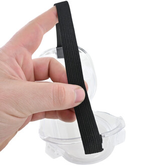 Lunettes de protection transparentes avec une sangle élastique noire en gros plan, tenue par une main.
