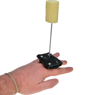 Main de feu confort fixée sur un doigt, avec une base en cuir noir et une mèche enroulée de tissu jaune. Une tige métallique soutient la mèche.