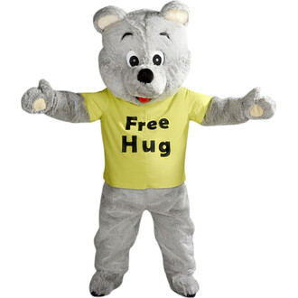 Costume de mascotte représentant un ours gris souriant, portant un t-shirt jaune avec l'inscription Free Hug. Les bras sont ouverts pour faire un câlin, et la mascotte se tient sur un fond blanc.