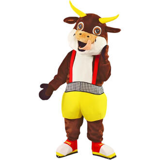 Mascotte de vache rigolote en peluche, debout, cornes jaunes, grand sourire avec langue sortie, portant bretelles rouges, short jaune et ceinture à motif vichy noir et blanc, ainsi que des chaussures rouges et jaunes.