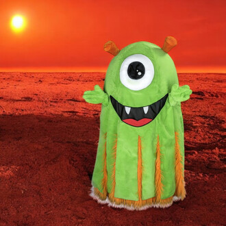 Mascotte représentant un alien vert avec un grand œil central, une bouche souriante avec des dents, et des antennes orange. Elle porte une tenue pelucheuse avec des poils orange sur le bas et se tient devant un paysage rouge.