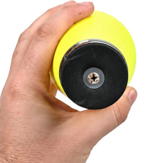 Main tenant une massue de jonglerie jaune par son embout rond noir avec une vis centrale, vue de près.