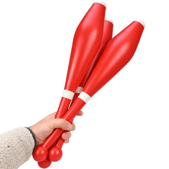 Main tenant trois massues de jonglerie rouges Flare avec embouts et anneaux blancs, tenues ensemble par une main.