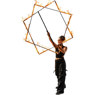 Ein Feuerkünstler hält einen geometrischen, sternförmigen Rahmen, ist von Flammen umgeben und schwarz gekleidet.
