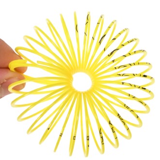 Mini Springy Licorne, un jouet en spirale jaune vif, tenu par une main, formant une forme circulaire avec des spirales à rayons.