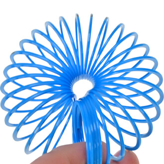 Mini Springy Dinosaure, ressort en forme de spirale bleu, tenu par une main, avec une vue rapprochée montrant ses spirales et son ouverture centrale.