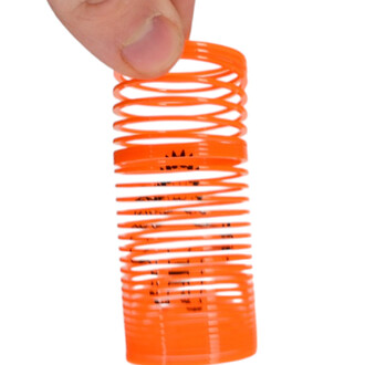 Mini Springy Dinosaure en spirale orange dans une main, avec une illustration de dinosaure à l'intérieur.