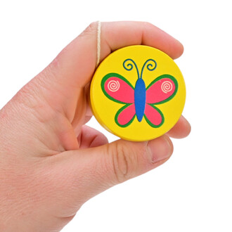 Une main tenant un mini yo-yo en bois, dont la face est peinte en jaune avec un dessin coloré d'un papillon rose et bleu. Le yo-yo est relié par une cordelette.