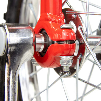 Monocycle Indy Deluxe Trainer 20 pouces – vue rapprochée du moyeu rouge et de l’axe de roue avec écrous et rondelles, jante et rayons argentés.