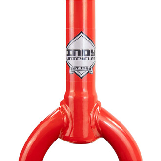 Monocycle Indy Deluxe Trainer 20 pouces, cadre rouge brillant avec le logo Indy Unicycles sur le tube de direction et les bras de fourche rouges visibles.
