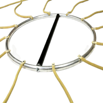 Vue rapprochée du tambourin Chakra avec son cadre en aluminium argenté, sa peau transparente tendue par des cordes en cuir beige et une baguette noire posée sur la membrane.