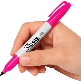 Gros plan d'un marqueur Sharpie à pointe fine rose tenu par une main, cap rose et corps blanc avec le logo Sharpie, sur fond blanc.
