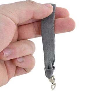 Une poignée gris en tissu Flowtoys avec mousqueton métallique à l’extrémité, tenue entre les doigts (une des deux poignées).