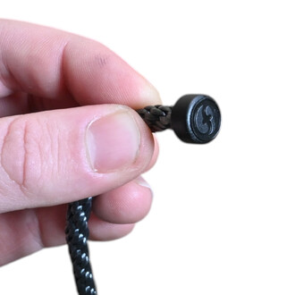 Gros plan sur une poignée PodPoi Flowtoys en nylon tressé noir, avec embout rond noir et logo Flowtoys gravé.