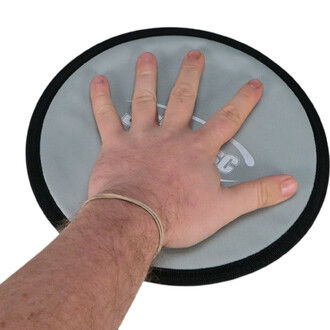 Main posée sur un patin glissant Sarneige, de forme ronde, avec une surface en tissu gris et un contour noir. Le patin présente un logo en blanc.