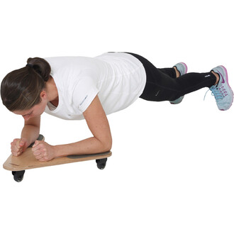 Femme en tenue de sport, effectuant un exercice de planche sur un plateau en bois, avec des roulettes. Elle est allongée sur le ventre, les avant-bras reposant sur le plateau et les pieds sur le sol. Ses vêtements sont un t-shirt blanc et un legging noir,