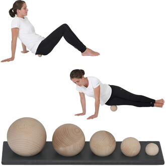 Image montrant une femme en T-shirt blanc et leggings noirs, pratiquant des exercices d'équilibre sur une balle en bois. La femme est en position assise sur une balle (partie supérieure) et en position de planche avec une balle en bois sous son ventre (pa