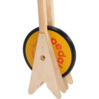 Support en bois avec un disque jaune et noir marqué pedal. Le disque est positionné sur un support en forme de triangle, permettant une démonstration ou une utilisation facile.