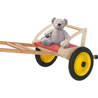 Chariot en bois avec roulettes jaunes, siège rouge et un ours en peluche gris assis dessus.