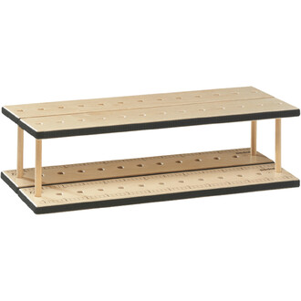 Plateau de jonglerie en bois, constitué de deux niveaux avec une surface perforée pour le rangement d'accessoires. Les bords sont noirs et des règles sont imprimées sur les côtés.